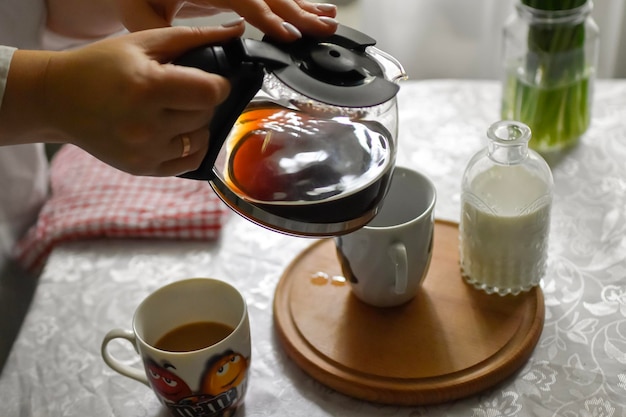Sitzgelegenheiten am Frühstückstisch mit Kaffeetasse und Milch