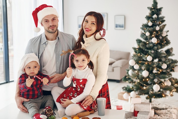 Sitzt gegen Tanne Schöne Familie feiert Neujahr und Weihnachten im Haus zu Hause