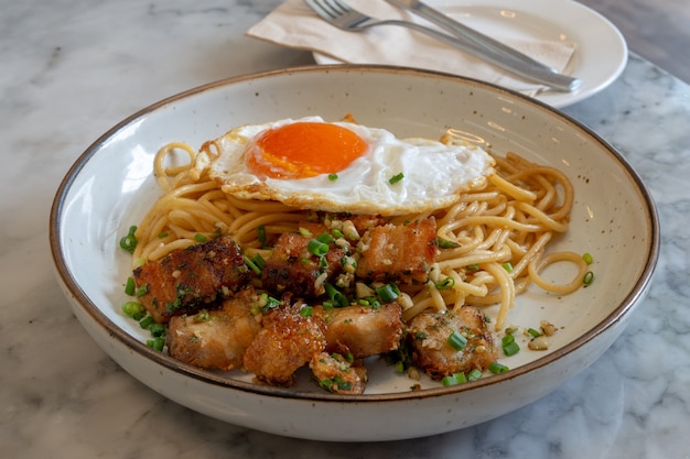 Sizzling heiß und cremig Spaghetti Knuspriges Schweinefleisch Carbonara mit Ei gekrönt