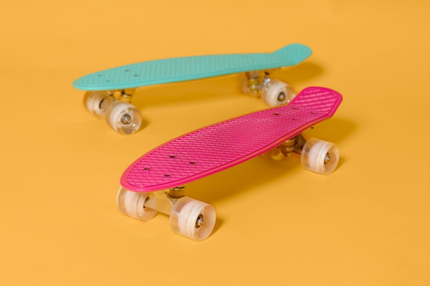 Skate de dois centavos rosa e verde isolado em fundo amarelo