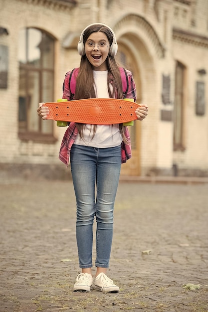 Skate de viagem perfeito Garota feliz segurando penny board urbano ao ar livre Viagem de verão Transporte Esporte e recreação Atividade recreativa Estilo de vida saudável Cultura de rua Música
