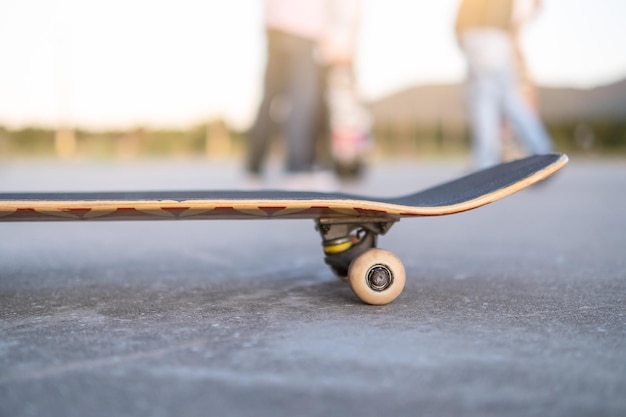 Skateboard im Vordergrund mit Skaterkindern, die im Hintergrund sprechen