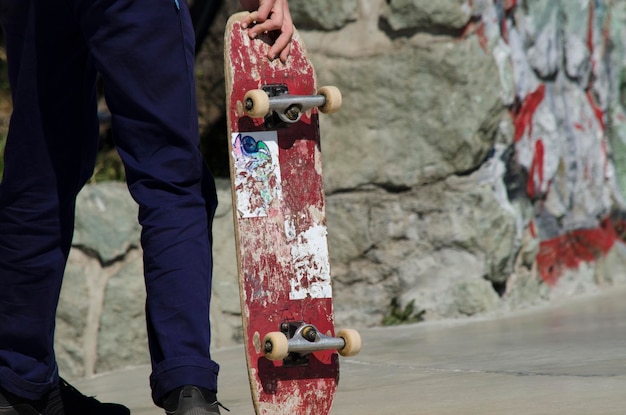 skateboarder segurando o skateboard com as mãos