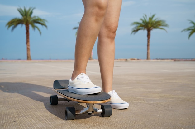 Skater cerca de las piernas con fondo de palmeras