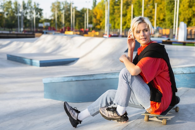 Foto skater femenino adolescente fresco con estilo en el parque de patinaje