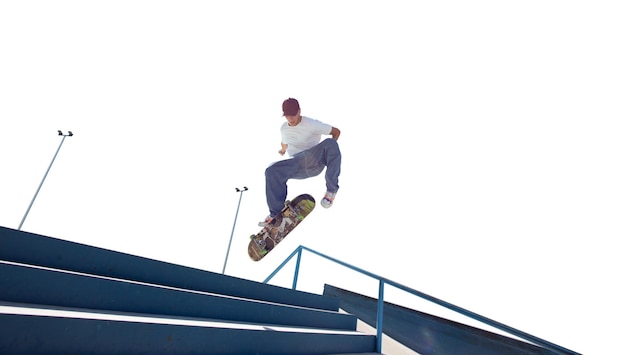 Skater haciendo un truco aislado en blanco