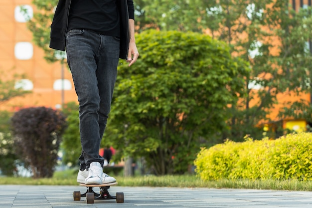 Skater de hombre elegante montando longboard en la ciudad