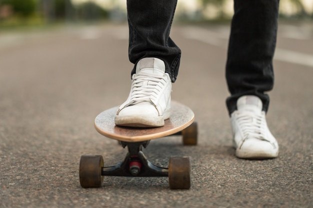 Skater de hombre de pie en longboard