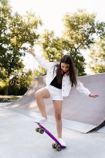 Skater Kind Mädchen Fahrt auf Penny Board auf Skate Sport Rampe bei Sonnenuntergang Sportgeräte für Kinder Aktiver Teenager mit Pennyboard auf Skate Park Spielplatz