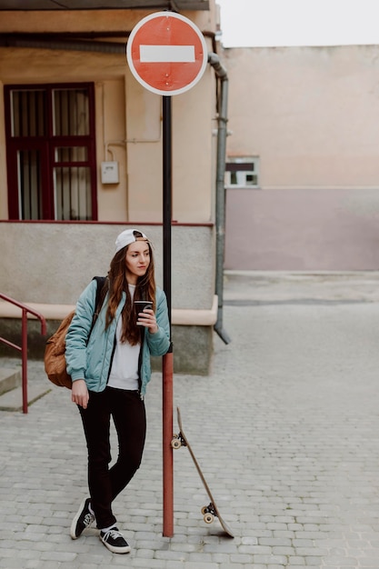 Skater Mädchen hält eine Tasse Kaffee