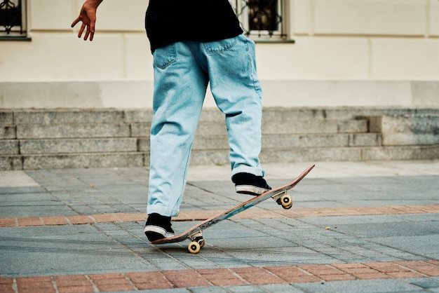 Skater paseo en patineta en las calles de la ciudad de cerca