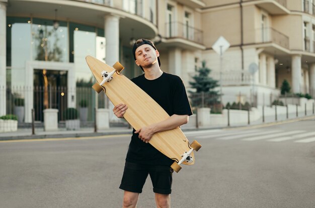 Skatista de cara posando com um longboard nas mãos