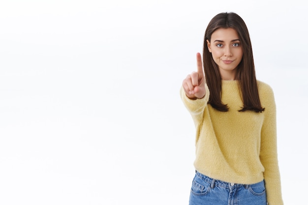 Foto skeptisch und ernst aussehende junge selbstbewusste frau verbieten handlungen, verbieten etwas, schimpfen die person mit missbilligendem ausdruck, schütteln den finger in der stopp-geste