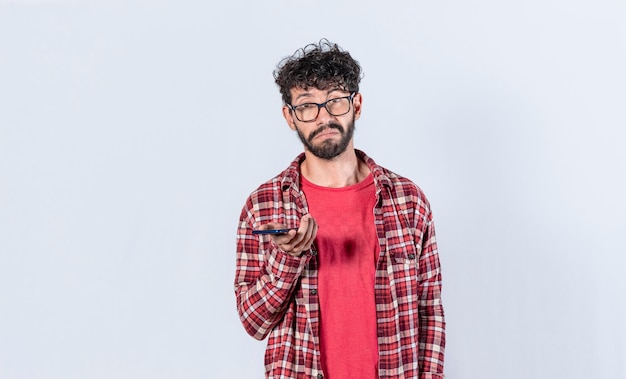 Skeptischer Mann mit Handy in der Hand Mann mit gleichgültigem und traurigem Gesicht Trauriger Mann mit Handy in der Hand