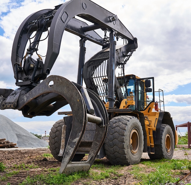 El skidder de garra industrial de función dual se coloca en el suelo al aire libre