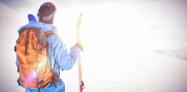 Skifahrer, der schöne schneebedeckte Berge betrachtet