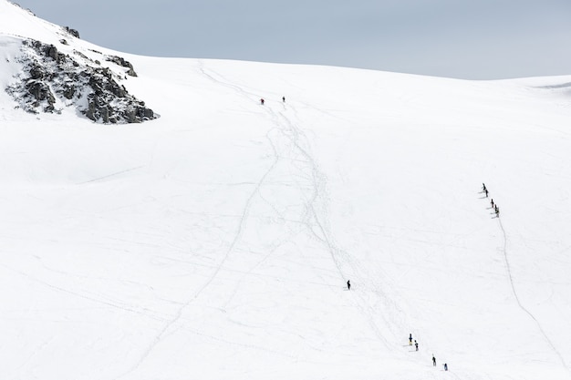 Skifahrer, die auf schneebedeckten Gebirgszügen gehen