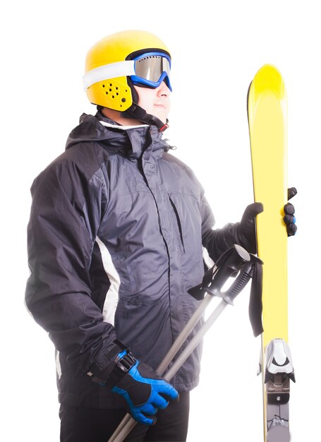 Skifahrer in Brille und Helm, hält Ski isoliert auf weiß