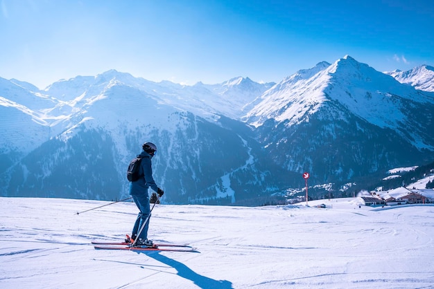 Skifahrer in Sportbekleidung Skifahren am Hang gegen die Bergkette