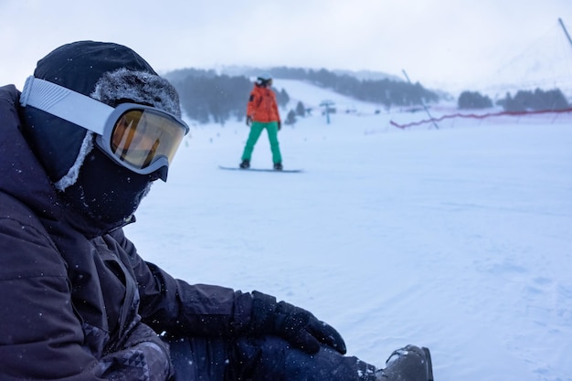 Skifahrer sitzt im Schnee der Skipisten und ruht sich vom Anstrengungsfoto mit Copyspace aus