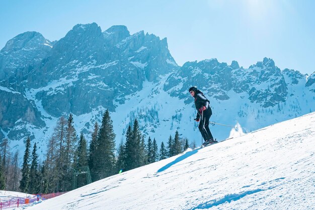 Skifahrer Skifahren auf schneebedeckter Abfahrt gegen den Berg im Winter