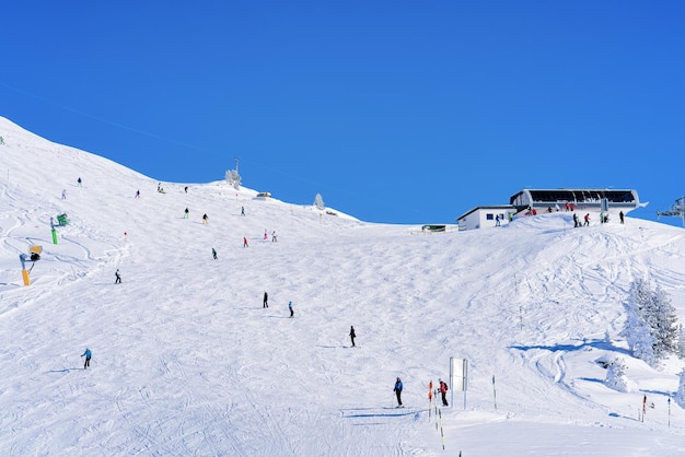 Skifahrer Skifahren im Skigebiet Zillertal Arena in Tirol in Mayrhofen in Österreich in den Winteralpen. Alpine Berge mit weißem Schnee und blauem Himmel. Abfahrtsspitzen an österreichischen schneebedeckten Hängen.