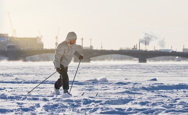 Skifahrerin, die auf Eis des gefrorenen Sees reitet
