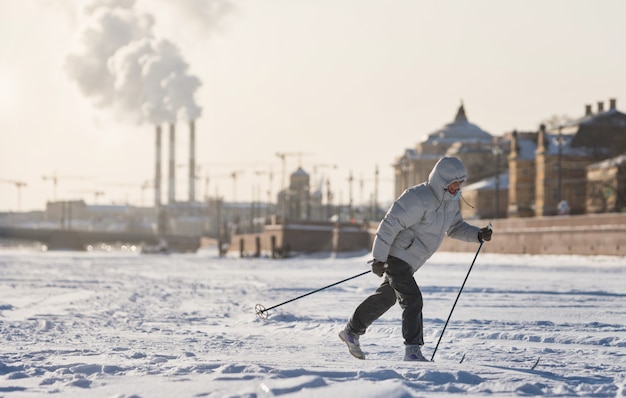 Skifahrerin, die auf Eis des gefrorenen Sees reitet