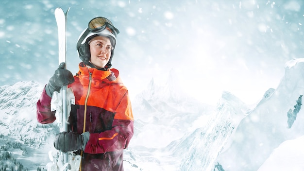 Skifahrerin, die mit dem Himmel in einer Hand auf dem Hintergrund der schönen Berglandschaft steht. Winter, Ski, Schnee, Urlaub, Sport, Freizeit, Lifestyle-Konzept