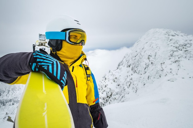 Skifahrerin posiert auf dem Gipfel des schneebedeckten Berges