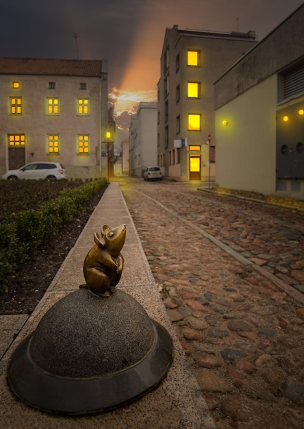 Skulptur der Maus in der Altstadt von Klaipeda, Litauen, beleuchtet von Laternen und Licht aus den Fenstern