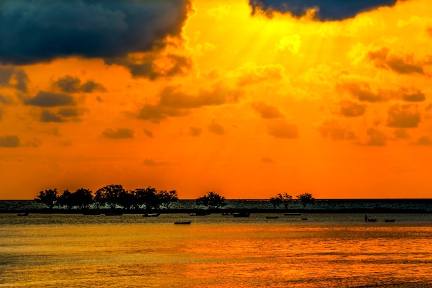 Skyscape, puesta del sol escénica en el mar con la silueta de barcos