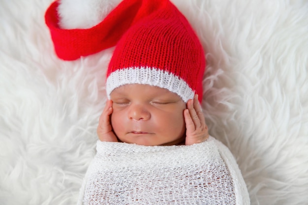 Sleeper bebé recién nacido en un gorro de Papá Noel de Navidad