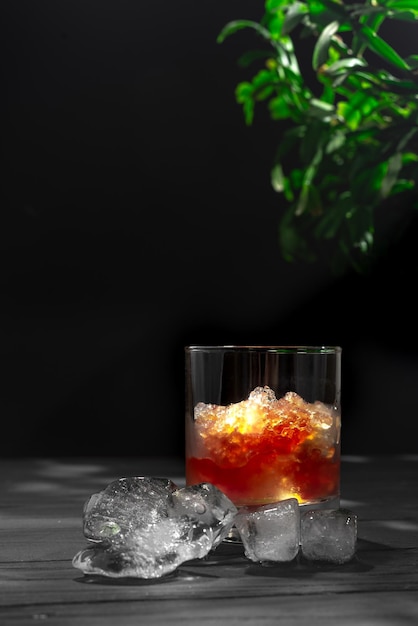 Slushies Whiskey-Cocktail mit Eis auf schwarzem Hintergrund mit Eiswürfeln