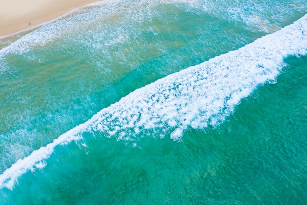 Smaragdmeer und kleiner Tourist, der auf dem Sandstrand am Surinstrand, Phuket Thailand liegt