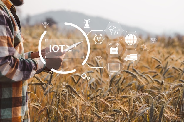 Smart-Farming-Konzept Landwirt mit digitalem Technologie-Tablet auf dem Hintergrund des Weizenfeldes Professionelle Landwirte nutzen das Internet der Dinge IOT-Computersystem, um die moderne Idee der landwirtschaftlichen Landwirtschaft zu verwalten