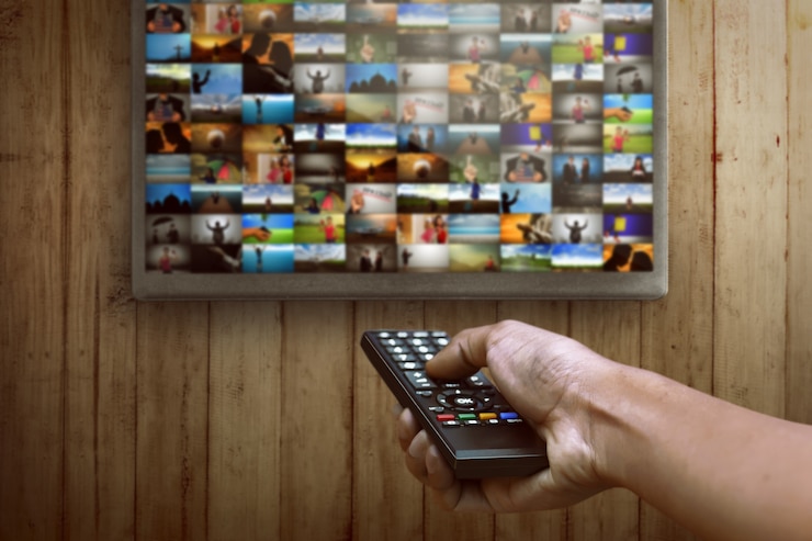 Foto smart tv e mão pressionando o controle remoto