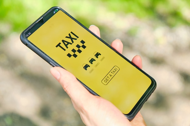 Foto smartphone con aplicación para elegir una clase de taxi en la mano