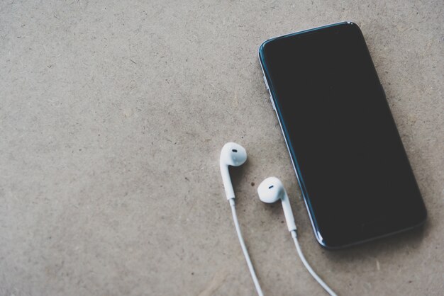 Smartphone y auriculares sobre fondo de madera