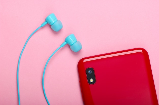Foto smartphone con auriculares de vacío en rosa