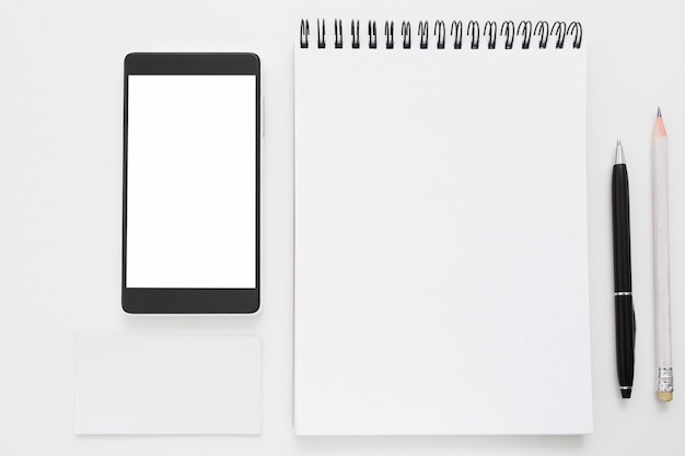 Smartphone y bloc de notas en blanco