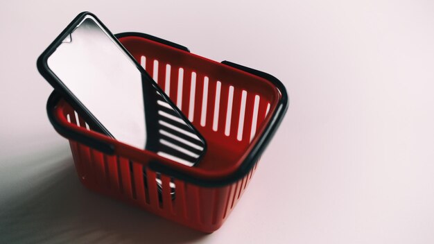 Foto smartphone en la canasta de compras roja concepto de compras en la tienda en línea comercio electrónico