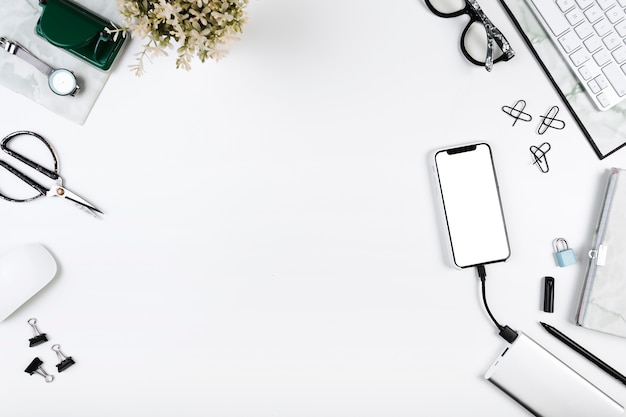 Foto smartphone cobrando no espaço de trabalho com ferramentas de escritório