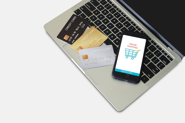 Smartphone com aplicativo de compras online na tela e um cartão de crédito no computador portátil. conceito de pagamento de compras online.