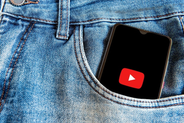 Smartphone com aplicativo do youtube no bolso da calça jeans