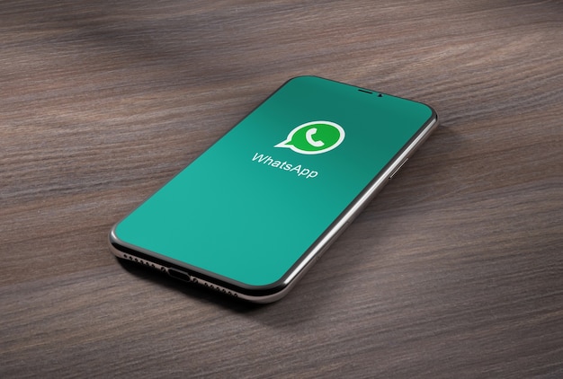 Smartphone com aplicativo whatsapp em mesa de madeira