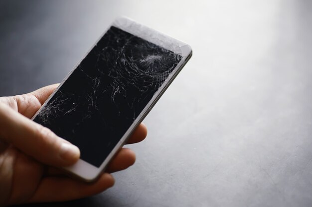 Smartphone com tela de toque quebrada. O celular está quebrado. O telefone travou. Substituindo o vidro quebrado em um telefone celular. Reparação de smartphones.