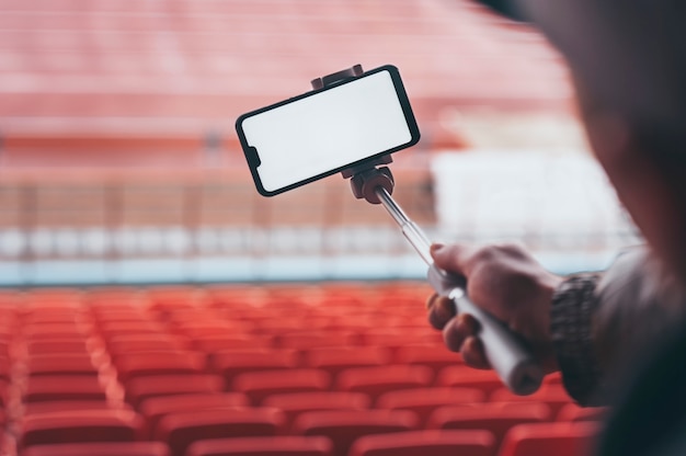 Smartphone com uma vara de selfie nas mãos