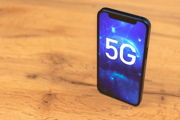 Smartphone con conexión a red 5G. Foto de fondo de madera