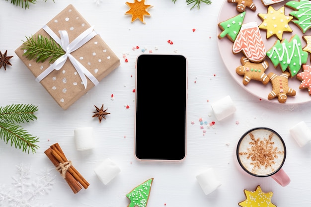 Smartphone de natal e presente em fundo de madeira